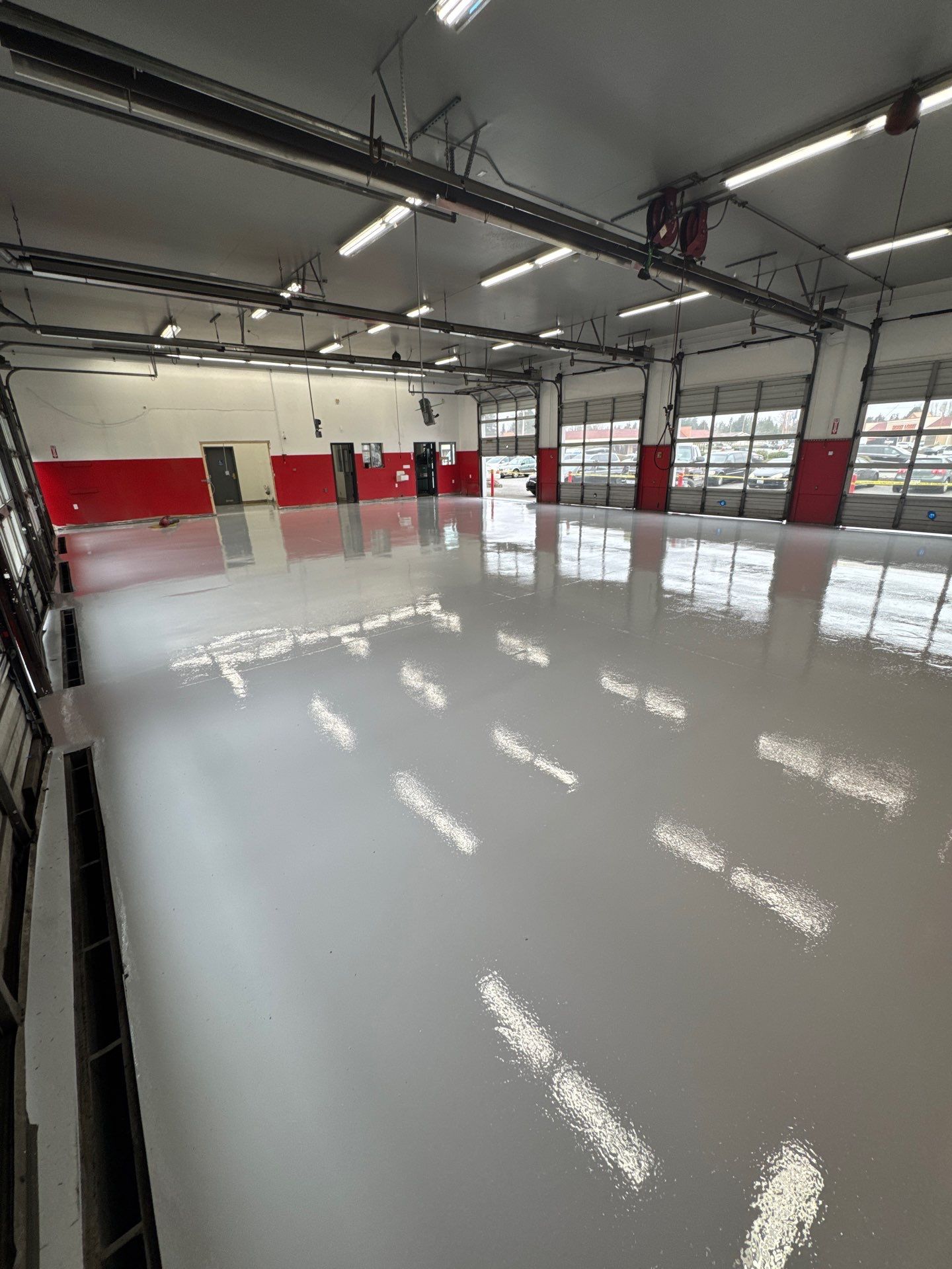 Glossy Light Grey polyurea floor in the Automotive Unlimited service bay in Everett