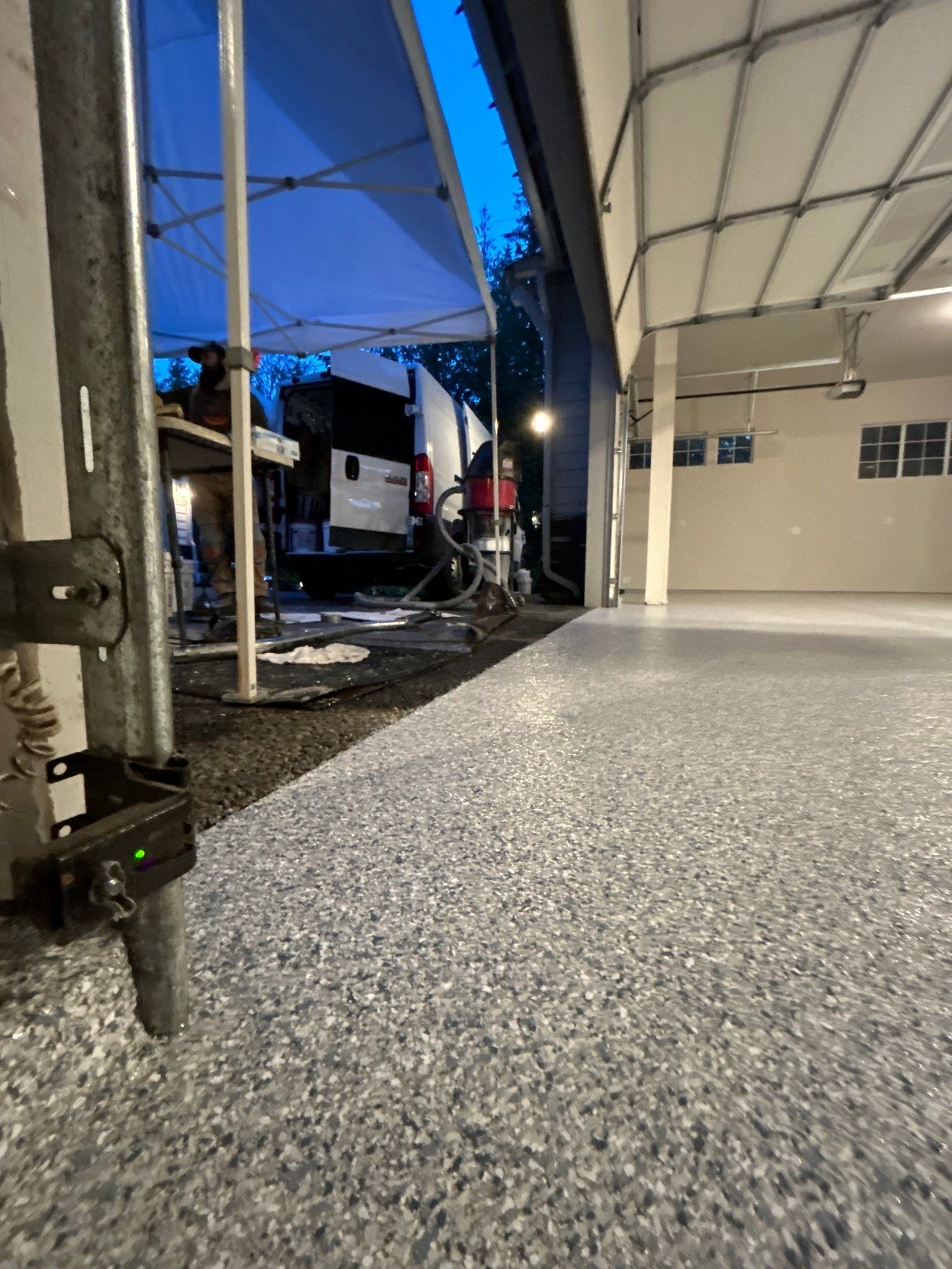 Freshly coated Tidal Wave flake garage floor at dusk with a canopy tent outside in Sammamish