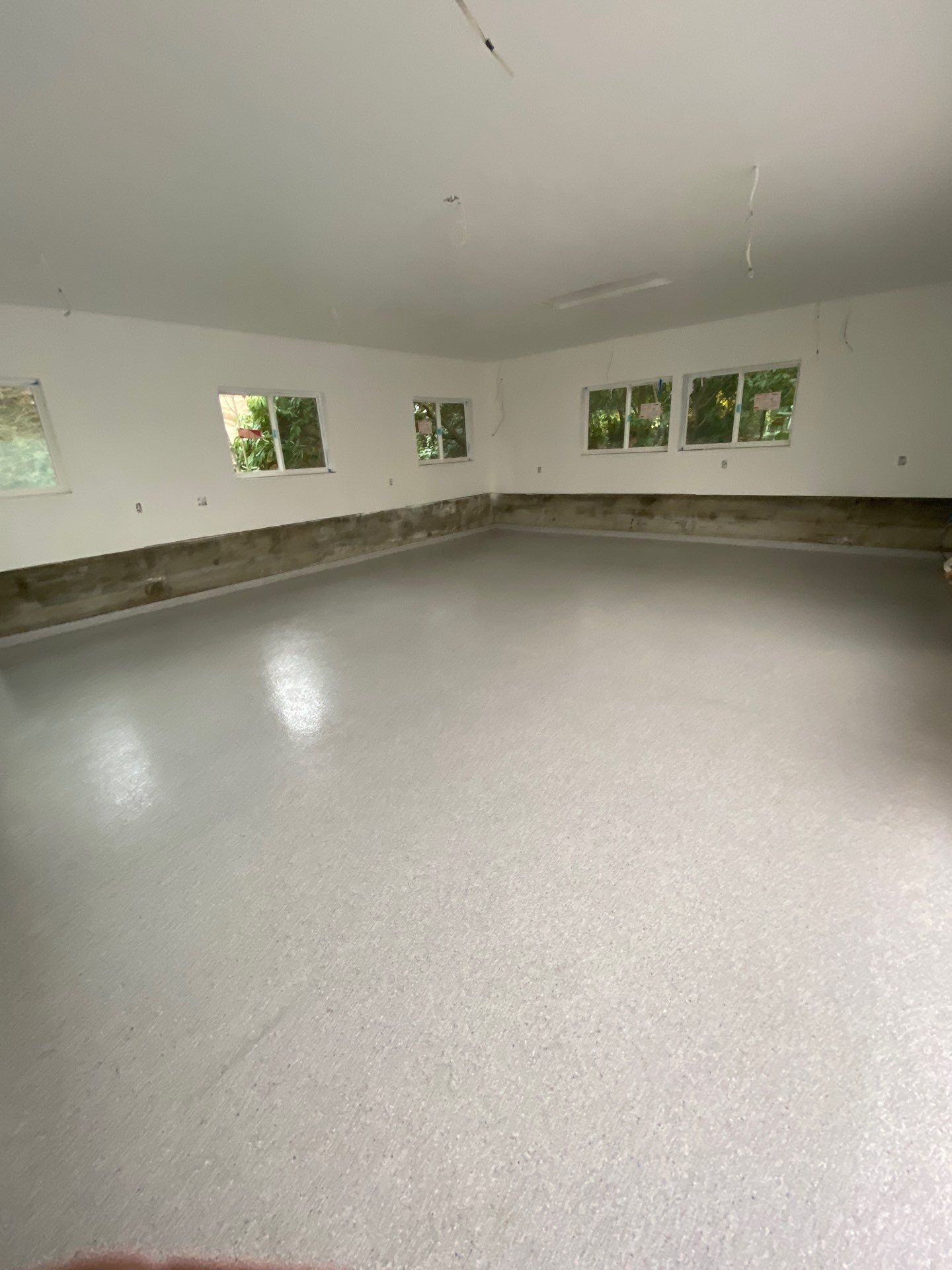 Large remodeled Shoreline garage with white walls and an Ash flake polyurea floor