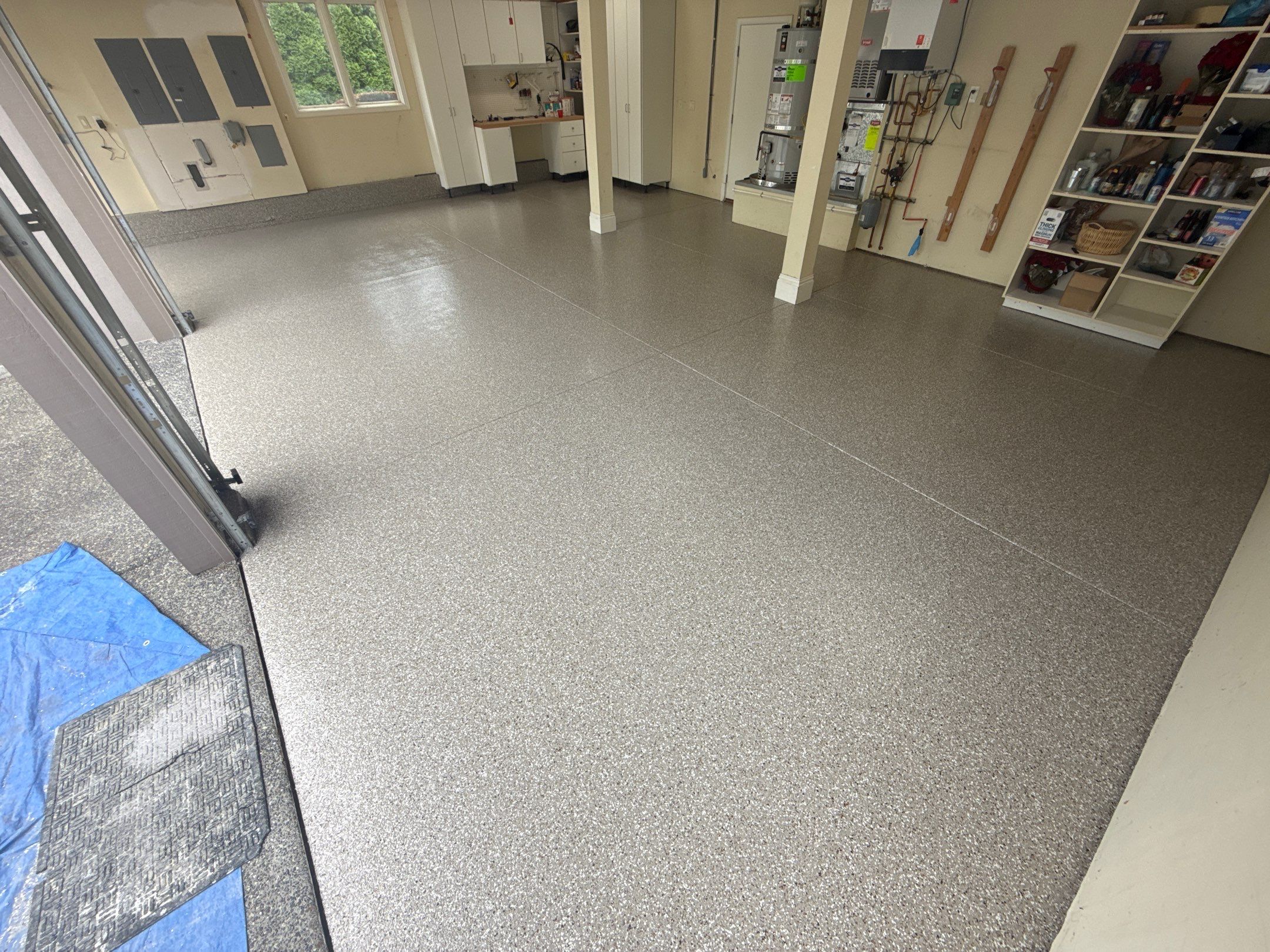 Pebble Beach flake polyurea floor with workbench and shelving in a Redmond garage