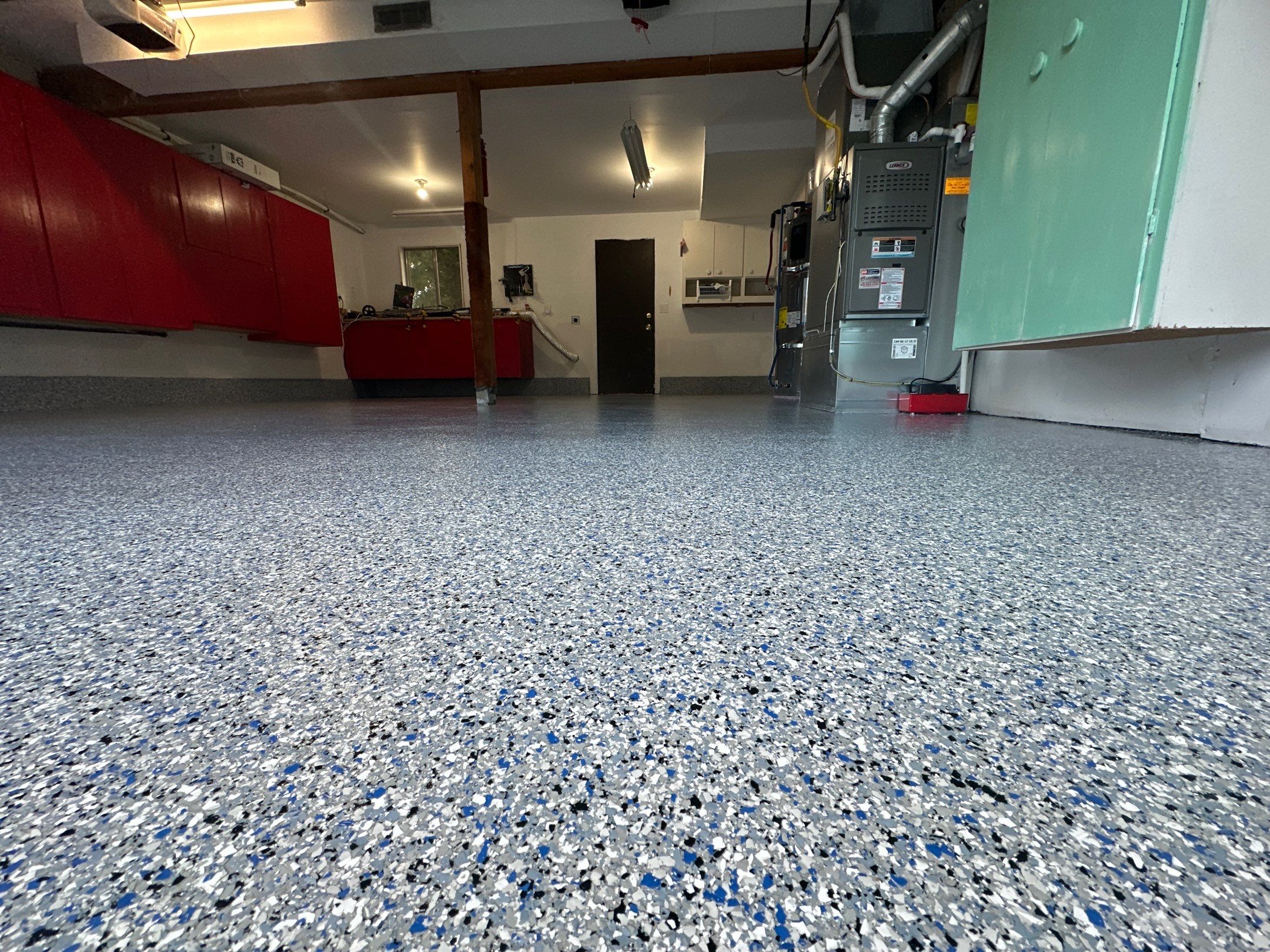 Comet flake polyurea garage floor with red cabinets and mint cabinets in Kirkland