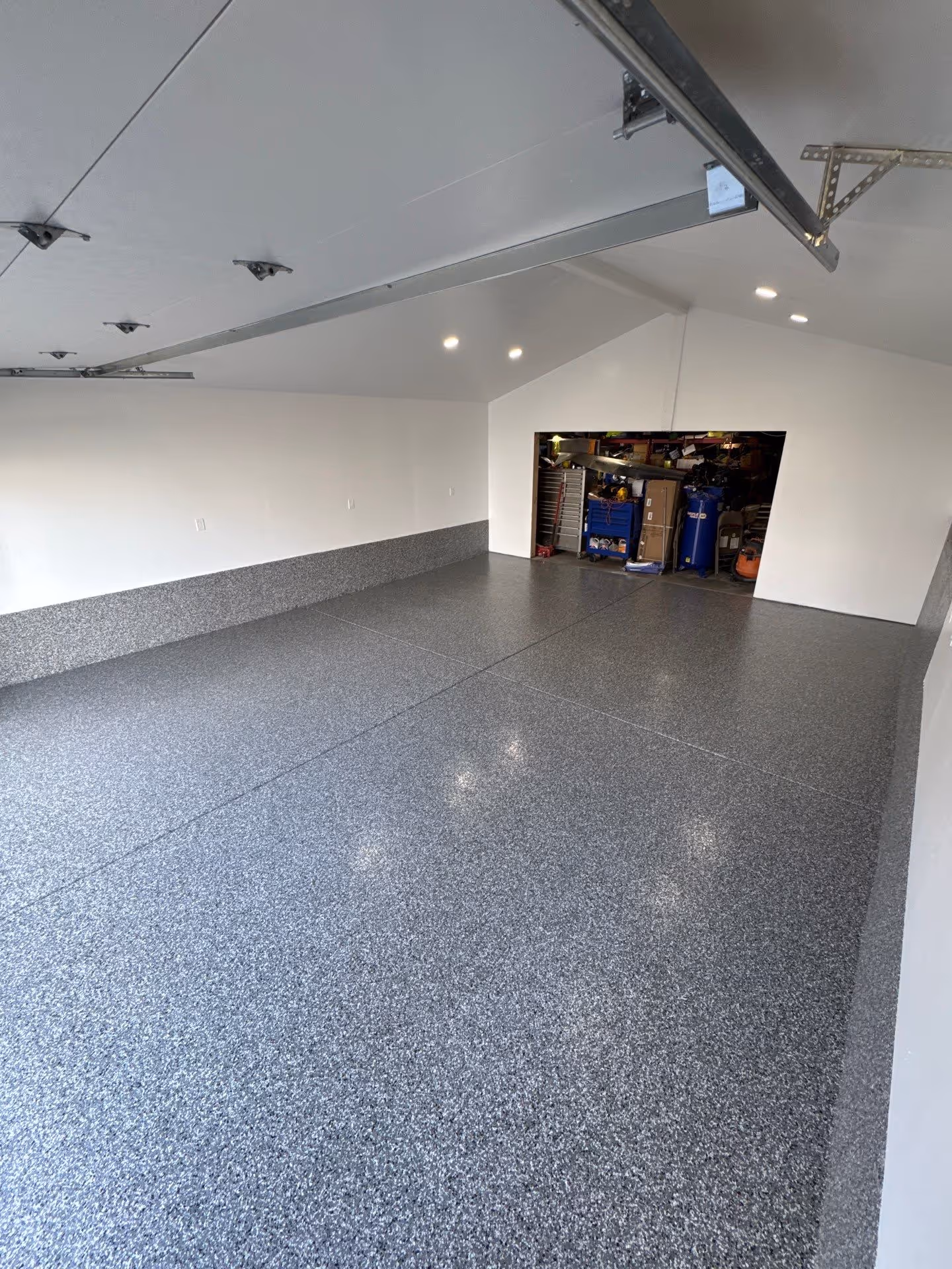 Smoke flake polyurea garage floor and flake wainscot under a vaulted ceiling in Tukwila