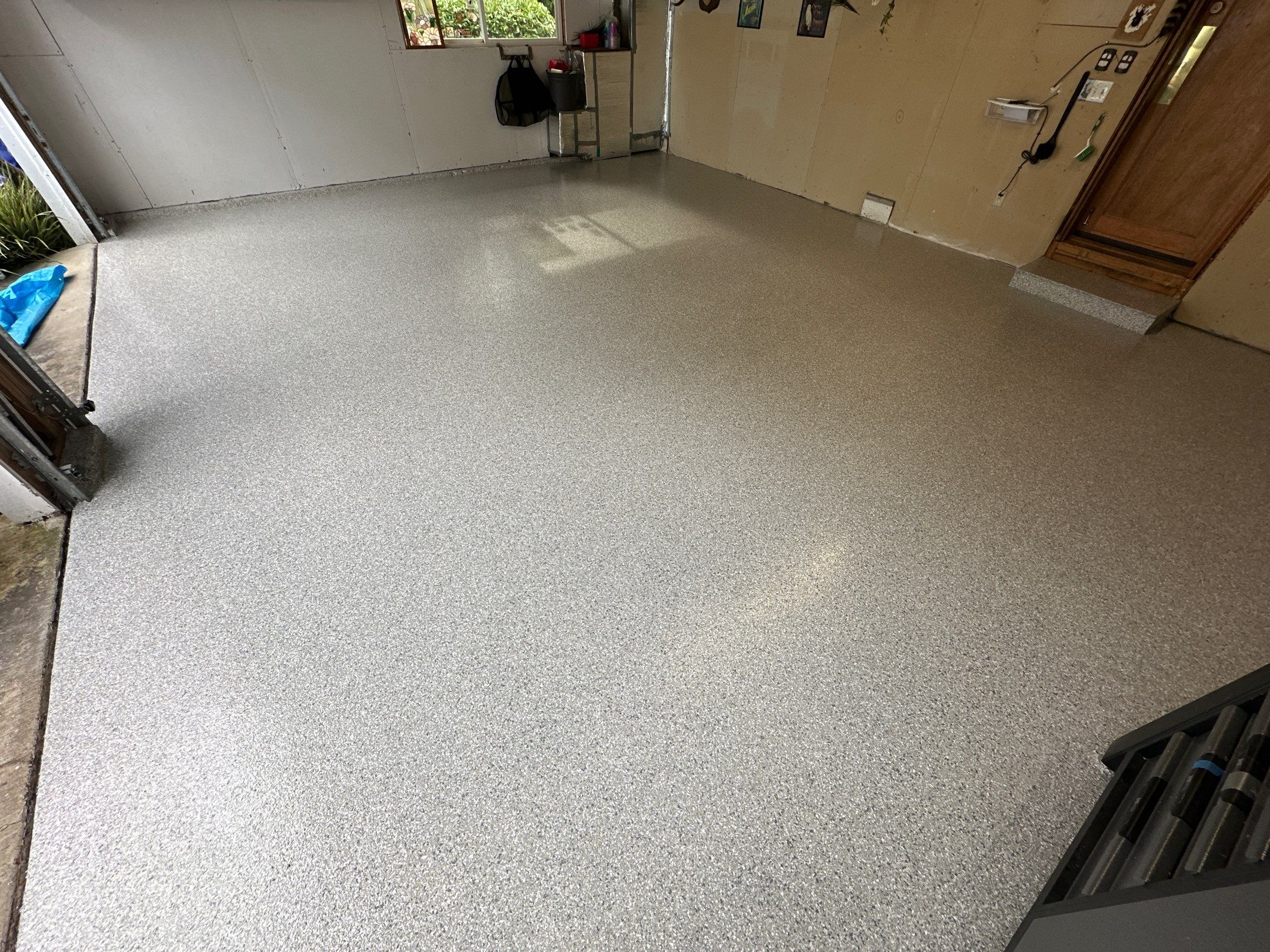 Mount Everest flake polyurea garage floor in a Carnation home with wood cabinets