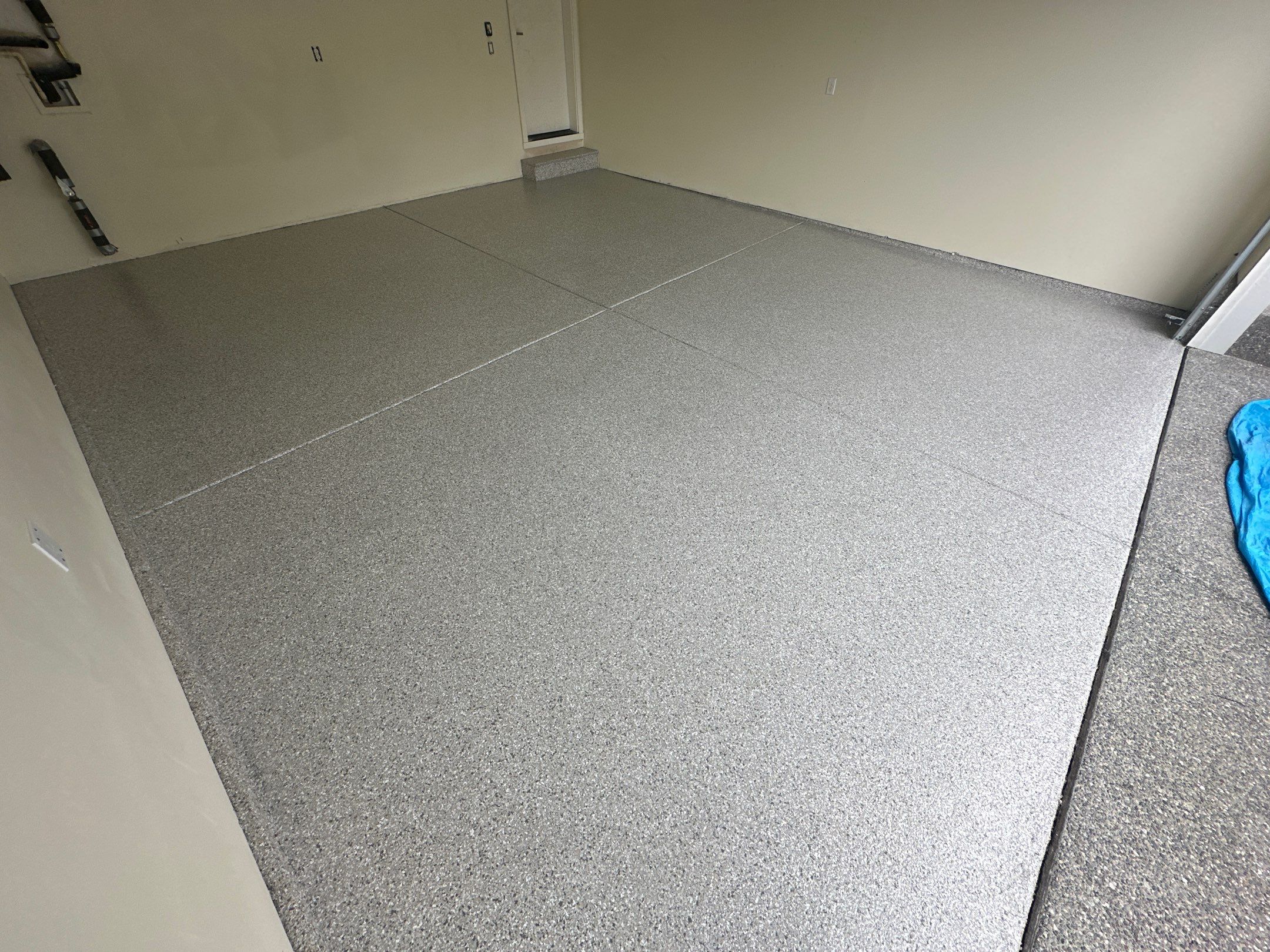 Mount Everest flake polyurea floor in an empty cream-walled Bothell garage