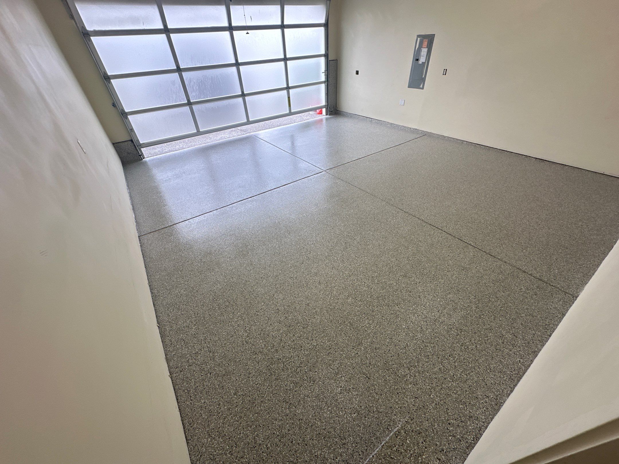 Light flake garage floor in front of a frosted glass garage door in Bothell