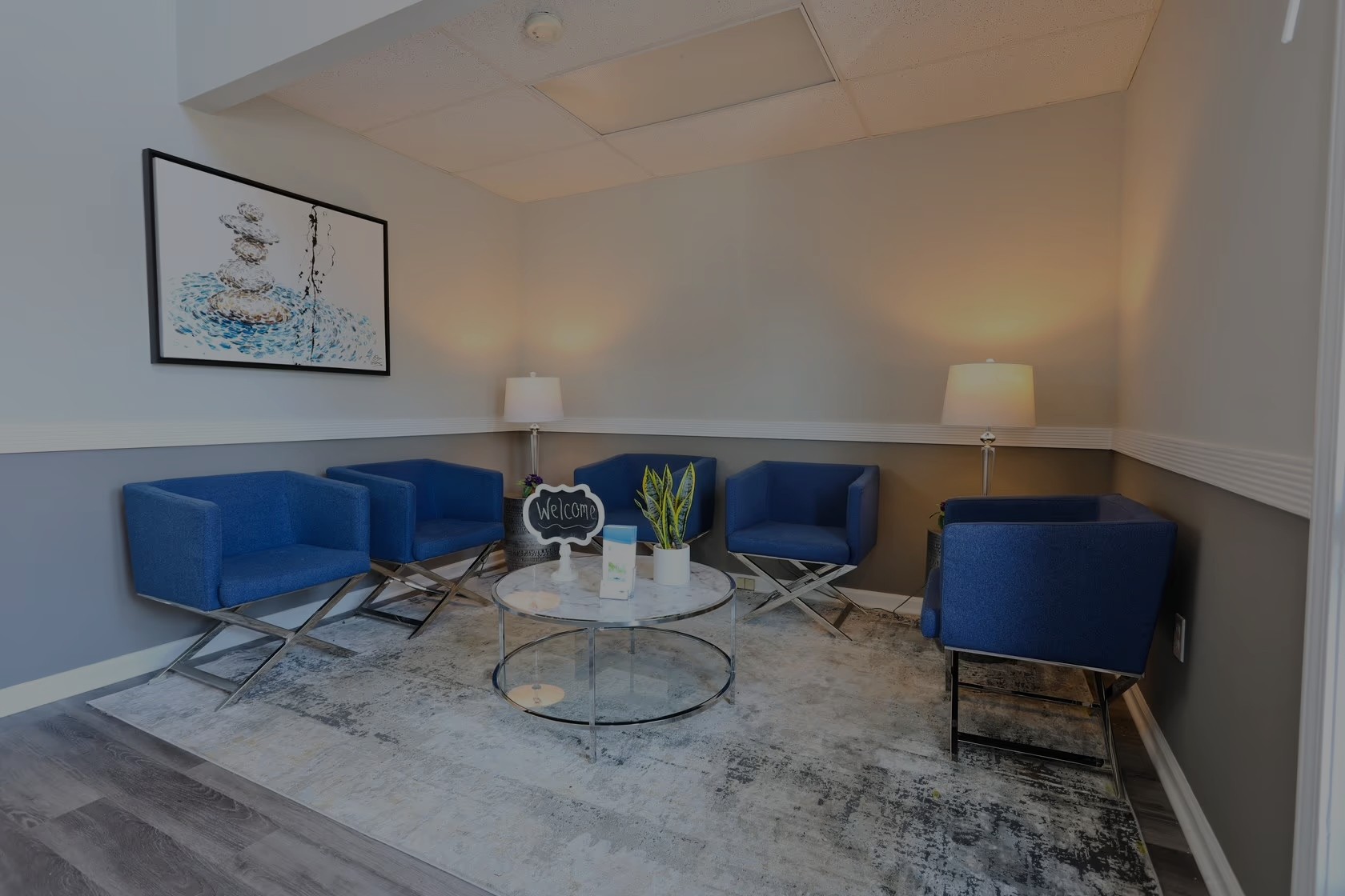 Inner Clarity waiting room with blue armchairs, a marble coffee table, and a welcome sign