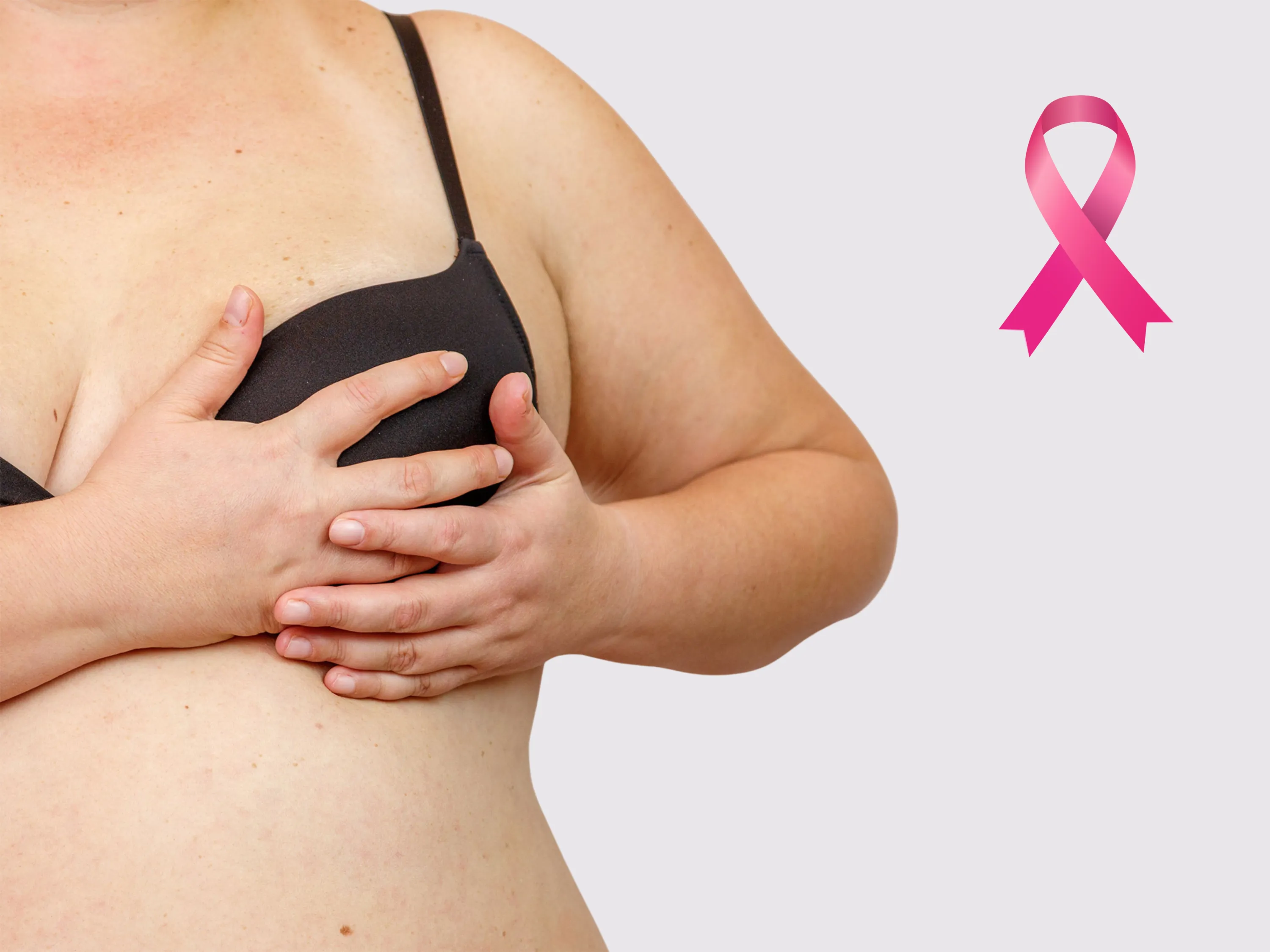 Eine Frau mit Übergewicht hält ihre Brust, daneben ein pinkes Schleifen-Symbol – das Bild verdeutlicht den Zusammenhang zwischen Übergewicht Krebs und einem erhöhten Risiko für Brustkrebs.