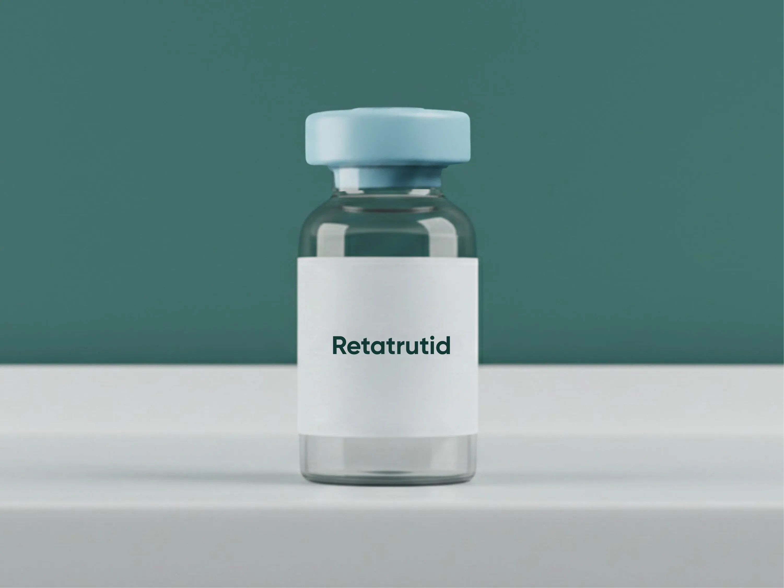 Glasfläschchen mit der Aufschrift Retatrutid auf weißem Tisch vor grünem Hintergrund als Darstellung eines Wirkstofffes zur Gewichtsreduktion.