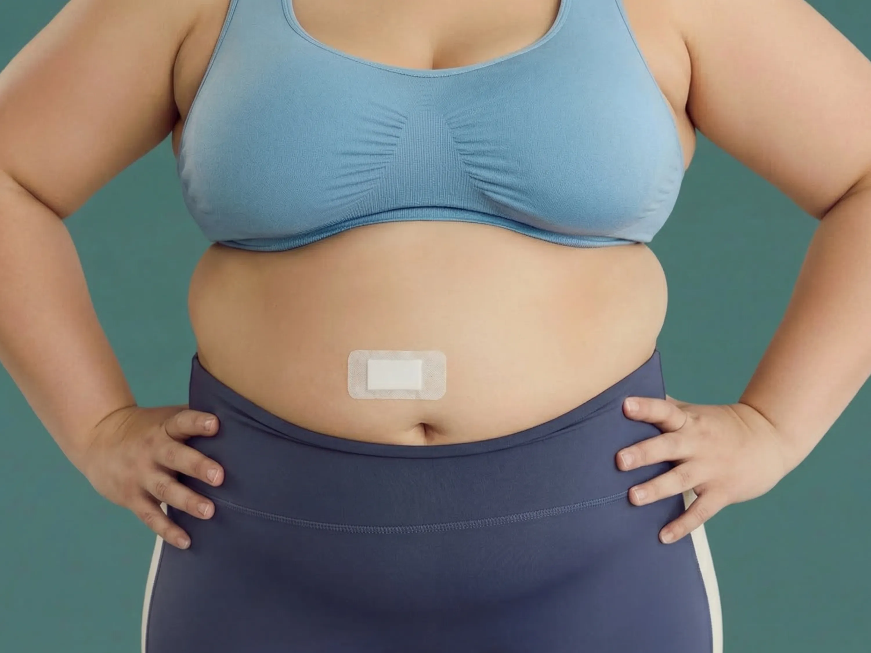 Frau mit sichtbarem Bauch trägt ein Abnehmpflaster als Unterstützung beim Gewichtsverlust.