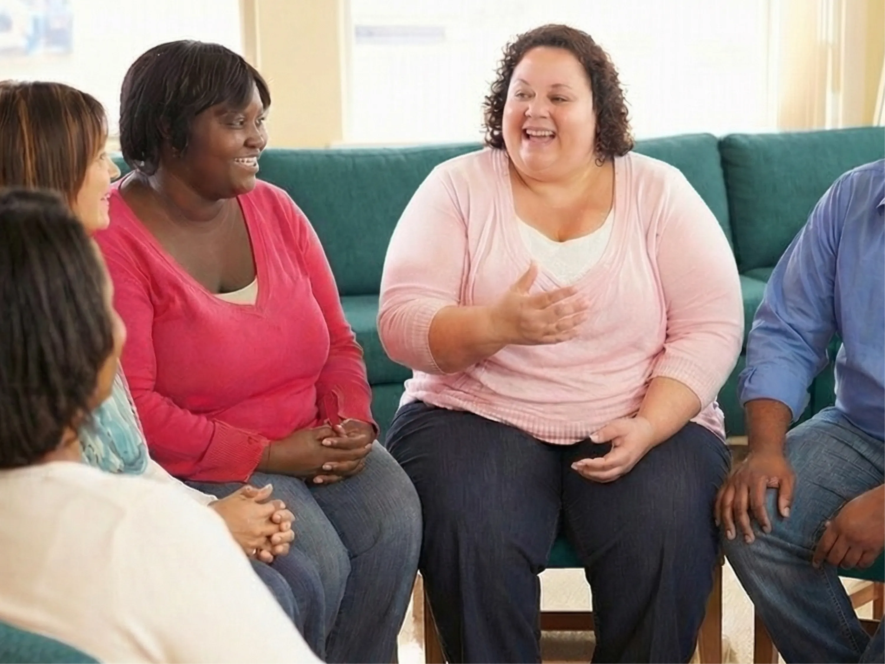 Frauen sitzen in einer Runde und tauschen sich in einer Adipositas Selbsthilfegruppe aus.