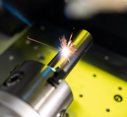 Funkenflug beim Laserbestrahlen eines metallischen Rohres im Labor.