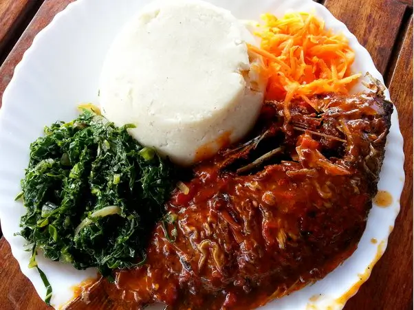 Ugali with collard greens and fish. Photo via Quora