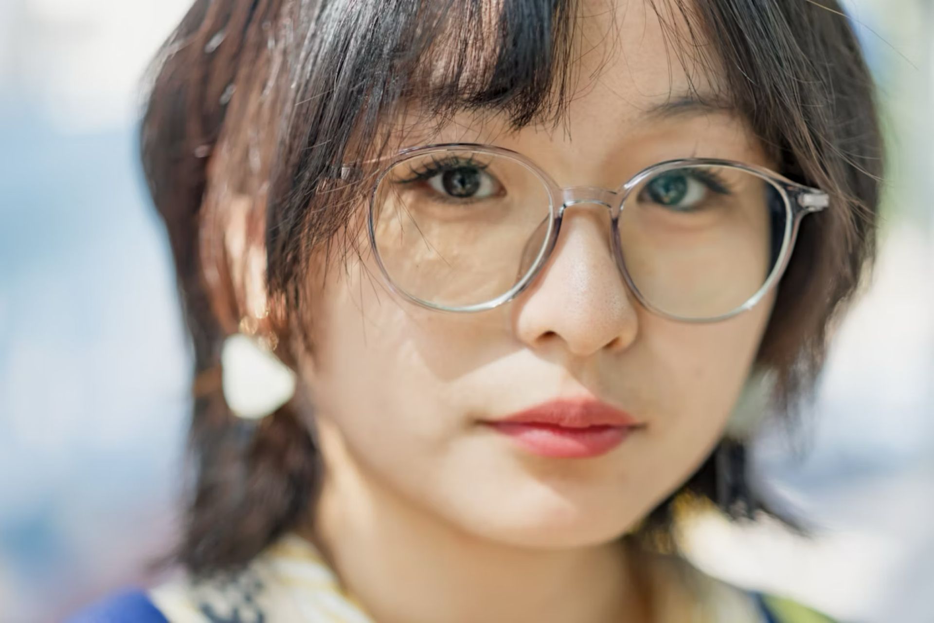Young woman with glasses looking thoughtfully to the side