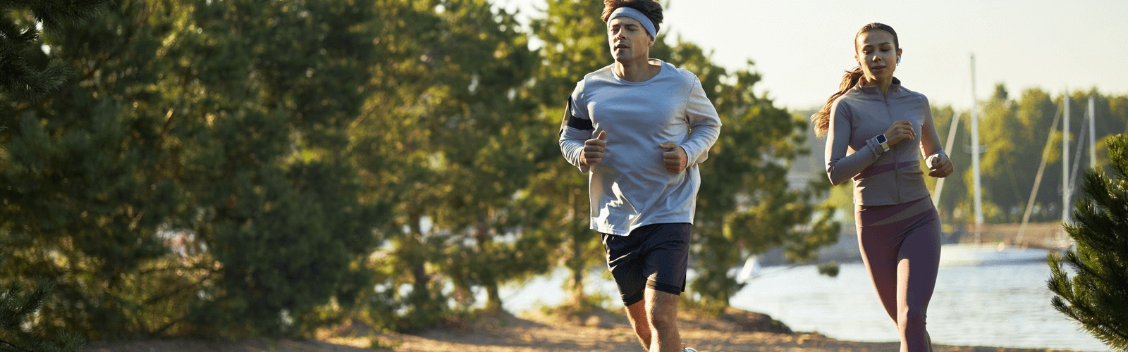 Active couple in Chicago jogging by the waterfront at sunrise work to rebuild energy and resilience after 40.