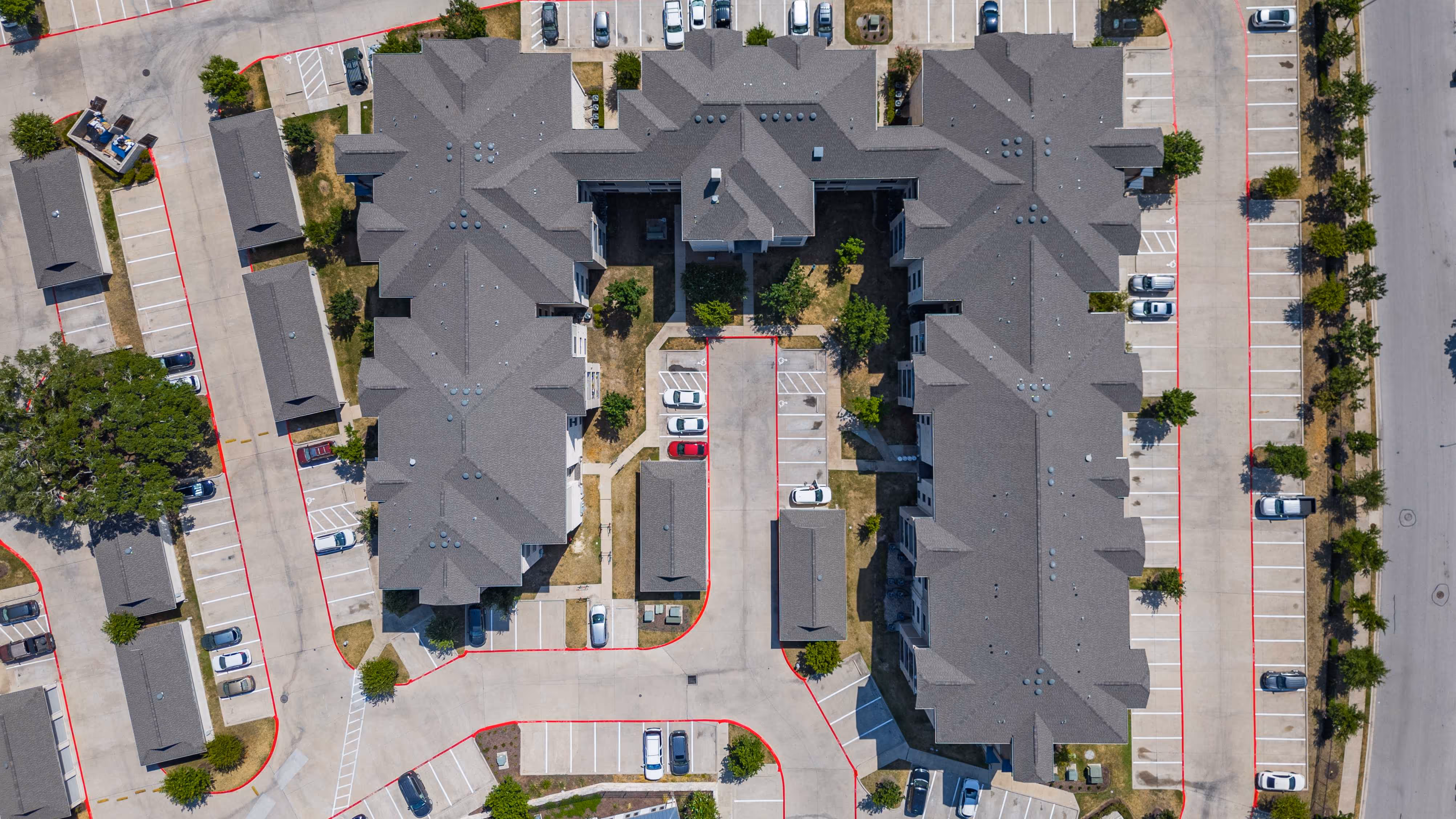 Large apartment building with shingle roof. 
