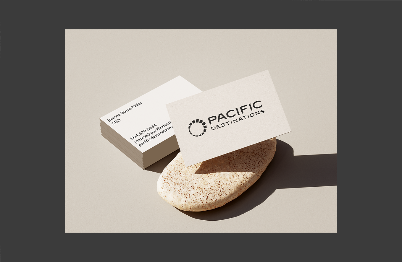 Stack of business cards with Pacific Destinations' logo and contact info.