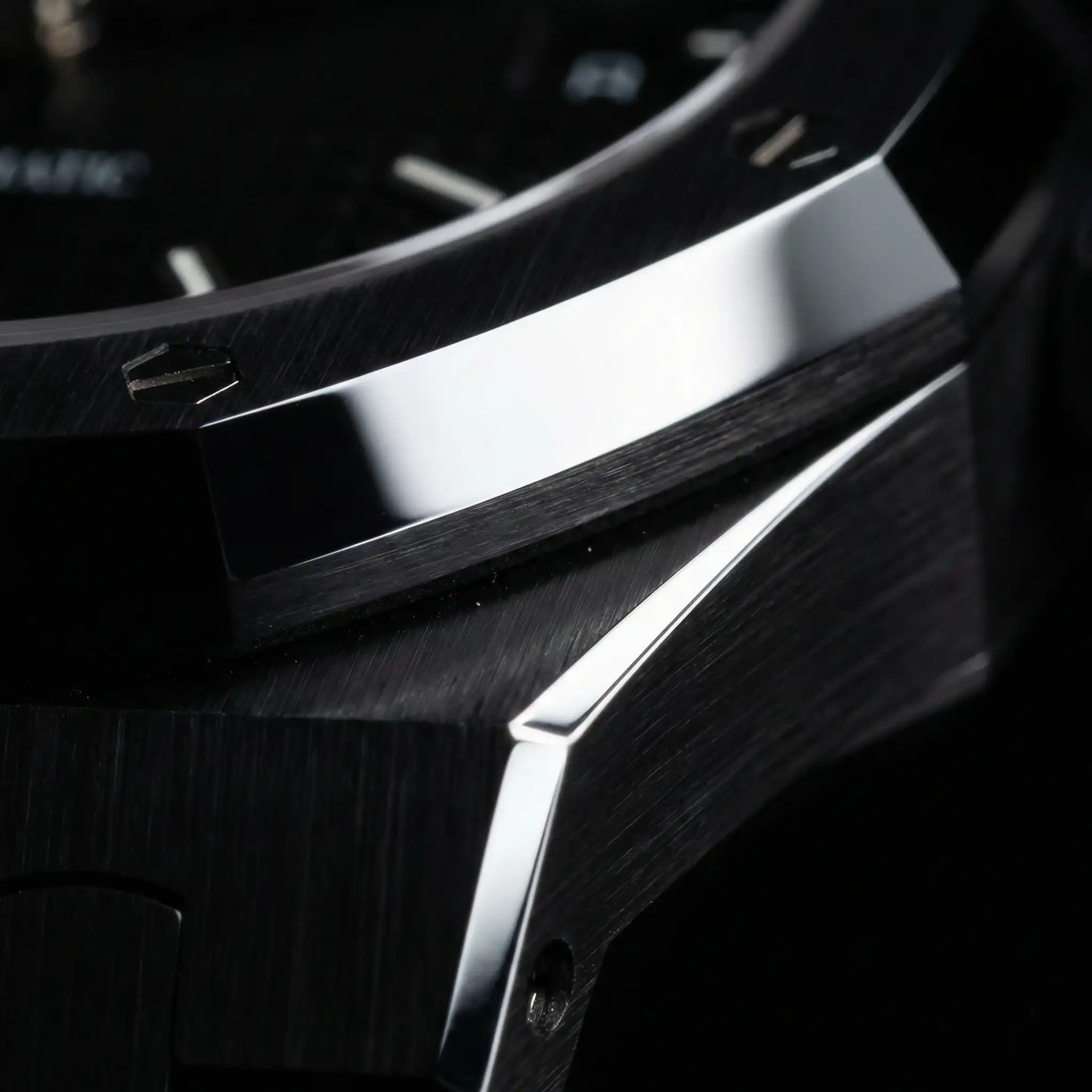 Macro photography of the Audemars Piguet Royal Oak in black ceramic, highlighting the hand-finished satin-brushed bezel and mirror-polished chamfers.