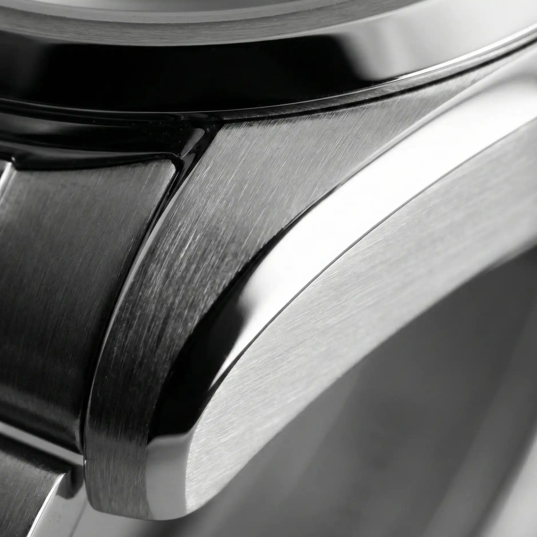 Macro photography of an unpolished Audemars Piguet Royal Oak lug, showing the razor-sharp definition of the polished chamfer against the vertical satin-brushed case.