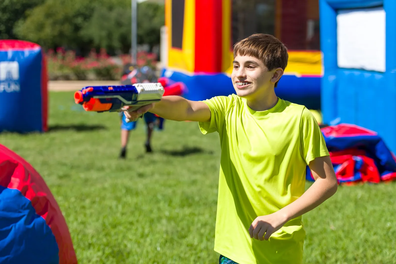 Kids playing Nerf with an inflatable bounce attraction in the background