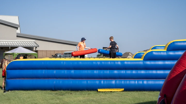 An inflatable joust rental setup outside.