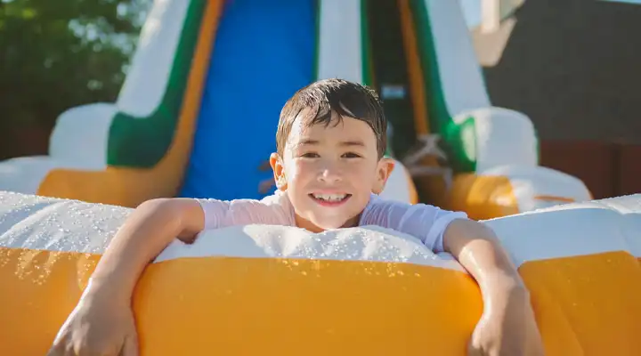 Inflatable water slide rental set up outdoors for a summer party