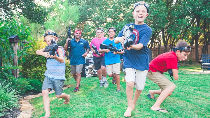 Kids running at an outdoor inflatable laser tag birthday party. Our mobile laser tag rental packages are great for team builders, birthdays, school events & more.