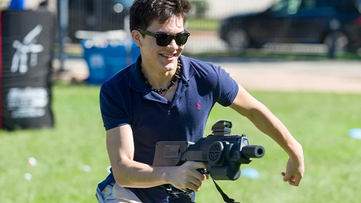 A boy playing with our laser tag equipment rental outdoors. Our mobile laser tag rental packages are great for team builders, birthdays, school events & more.