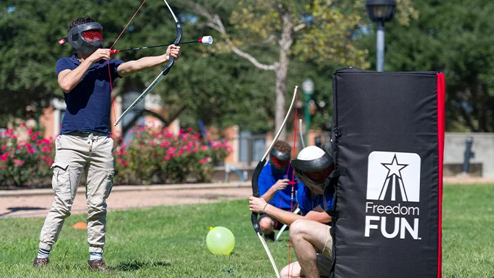 2 adults hosting a team builder for an archery tag rental