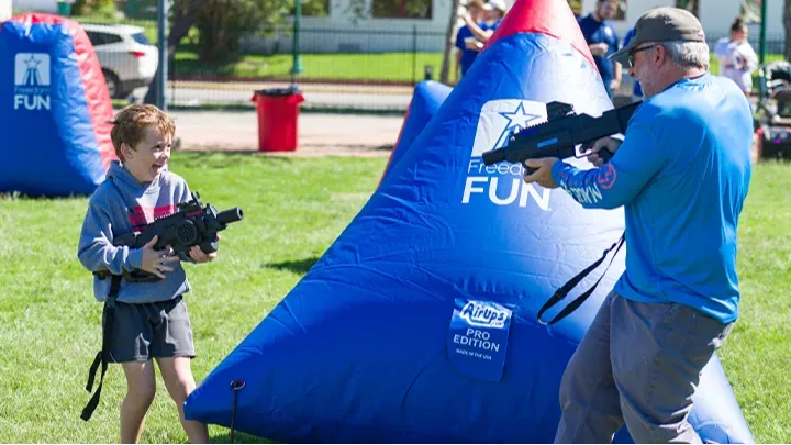 A boy playing with our laser tag equipment rental outdoors. Our mobile laser tag rental packages are great for team builders, birthdays, school events & more.
