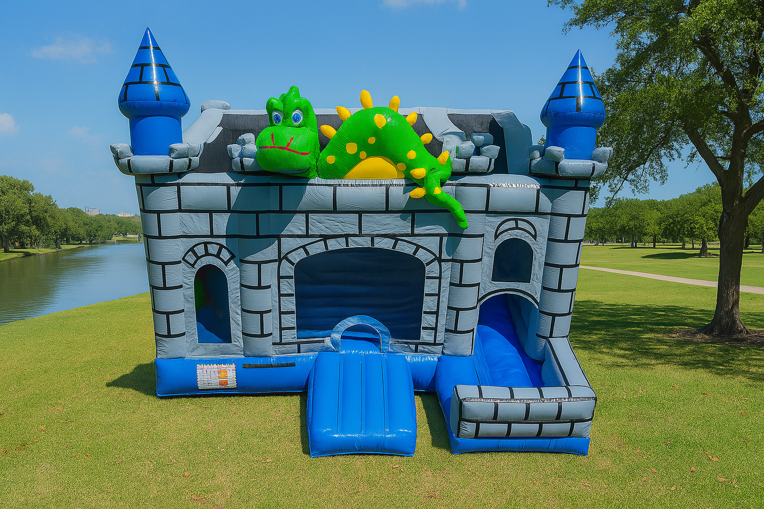 Inflatable dragon castle bounce house set up in a sunny Central Texas park near a river in Austin, TX , with vibrant blue turrets and a green dragon perched on top