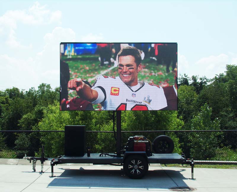 12x7 mobile LED screen displaying a high-resolution image of a football player in broad daylight, mounted on a compact trailer setup ideal for small to mid-sized outdoor events.