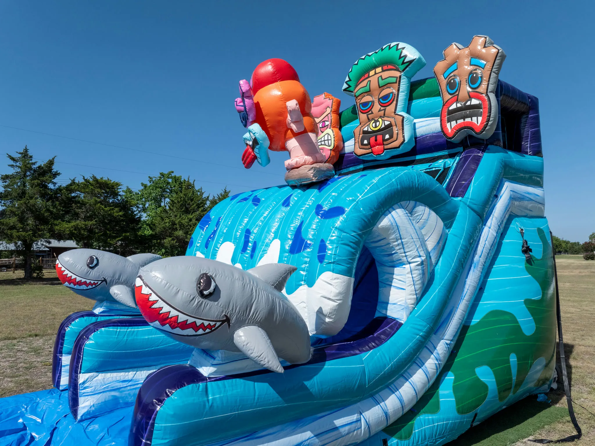 A giant blue inflatable waterslide rental setup outdoors