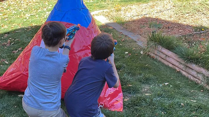 2 kids playing with our nerf laser tag equipment rental in the backyard for their laser tag birthday party. Our mobile laser tag equipment rental packages are great for team builders, birthdays, school events & more.