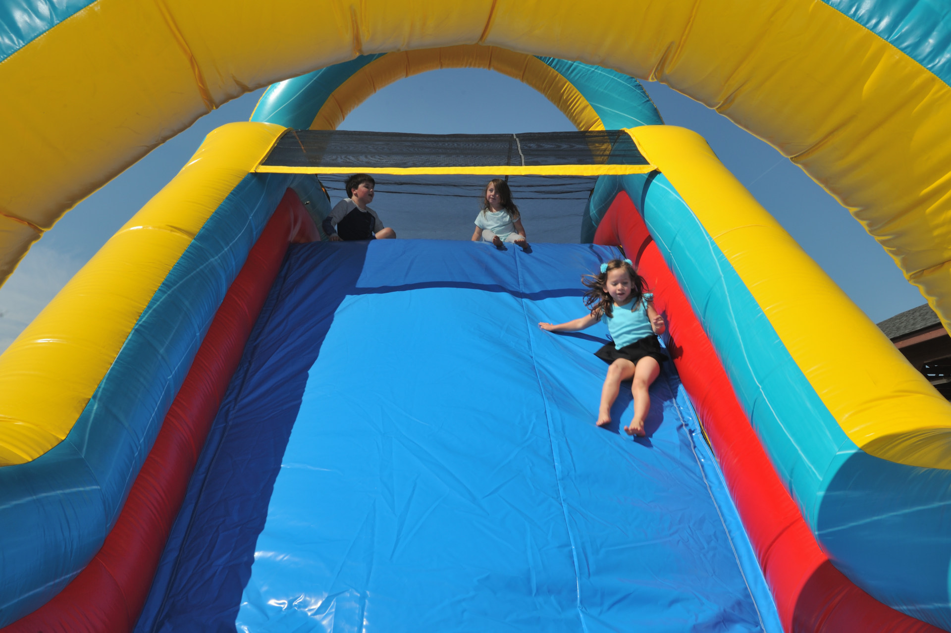 a cute girl on inflatable bounce house slide at freedom fun usa north carolina grand opening 