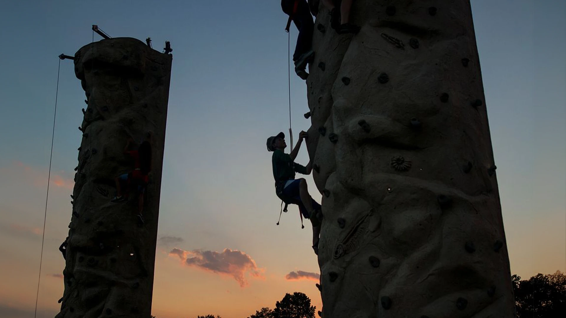 Kids climbing a portable rock wall rental at a school carnival.