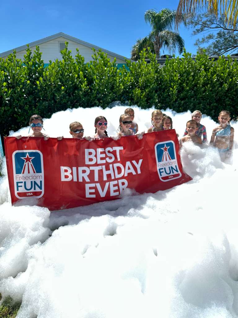 Kids running through mountains of foam at a Freedom Fun foam party