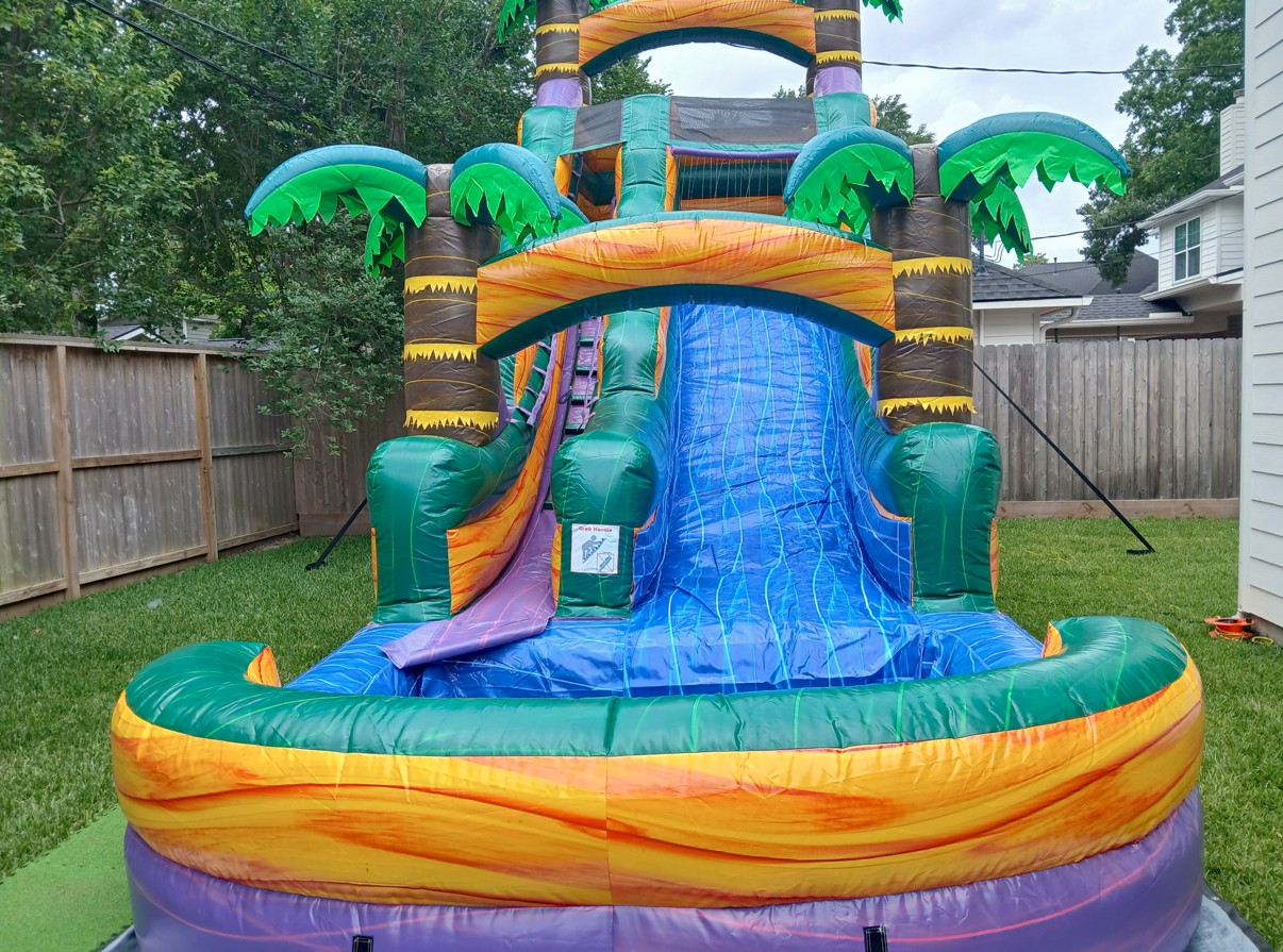 A giant purple inflatable waterslide rental setup outdoors