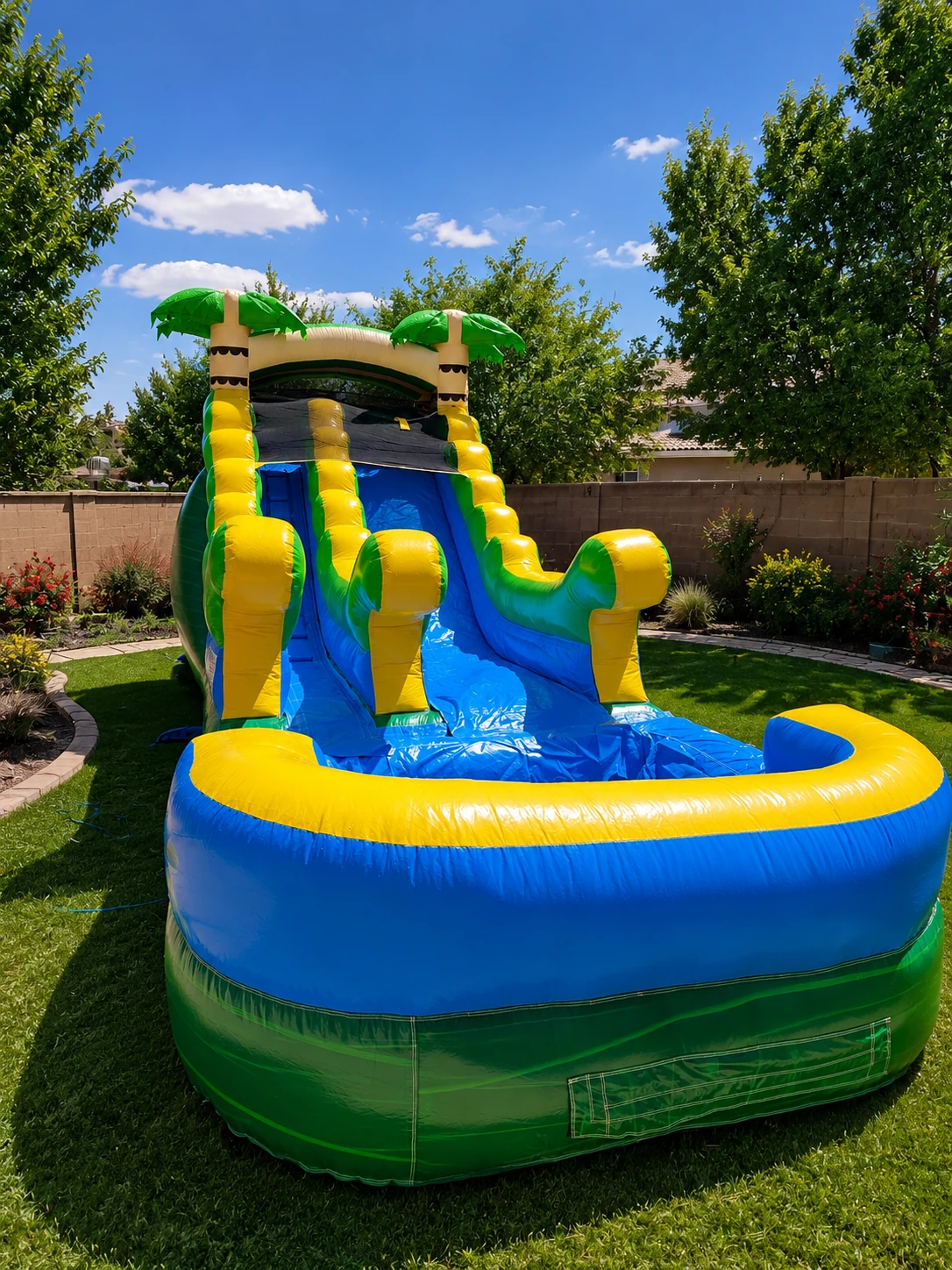Front view of the Freedom Fun Coconut Cove 14' tropical waterslide rental with splash pool in Albuquerque NM