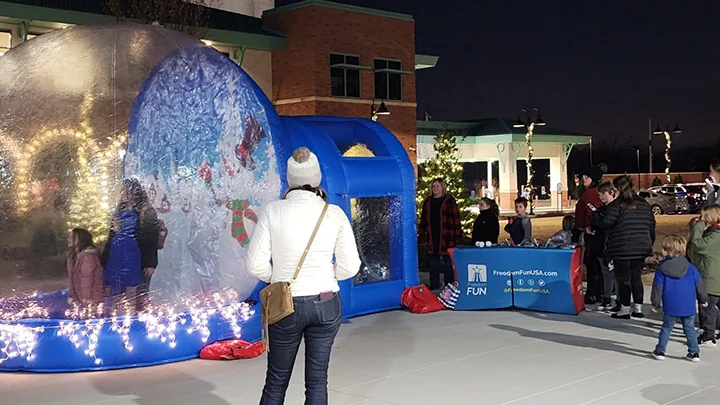 Kids inside a walk-in snow globe rental.