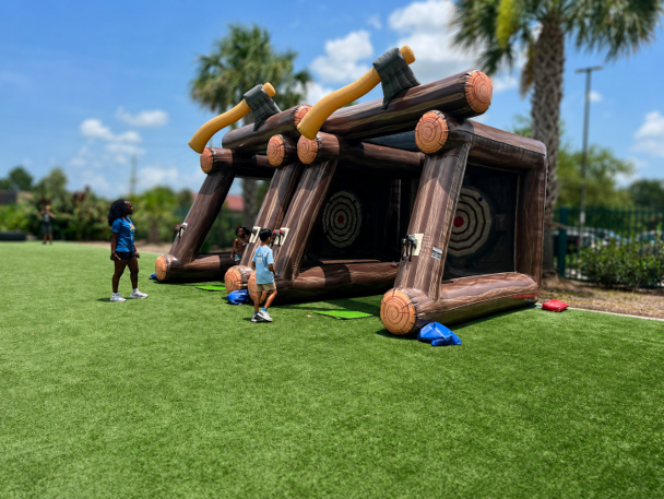 Two-lane inflatable axe throwing game set up outdoors.