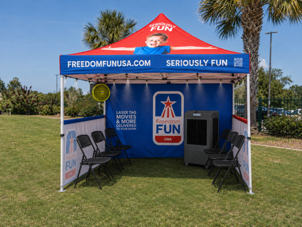 Outdoor cooling station tent with portable evaporative coolers and seating.