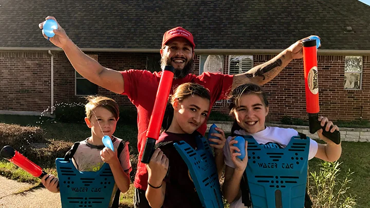 A family posing with a water tag rental at a birthday party.