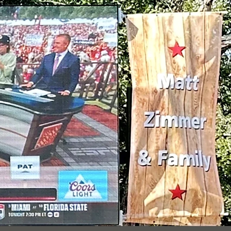 Custom sponsor banners mounted on both sides of a mobile LED screen trailer