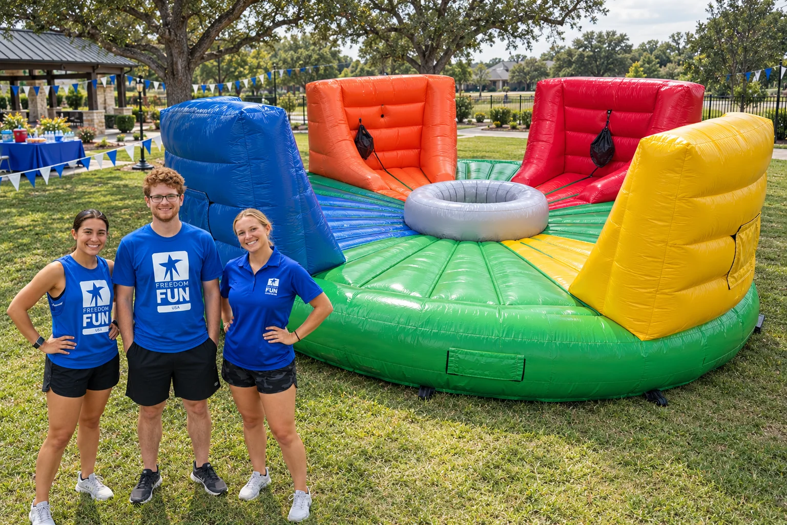 Three Freedom Fun coaches beside the Hungry Hippo inflatable at an outdoor event setup.