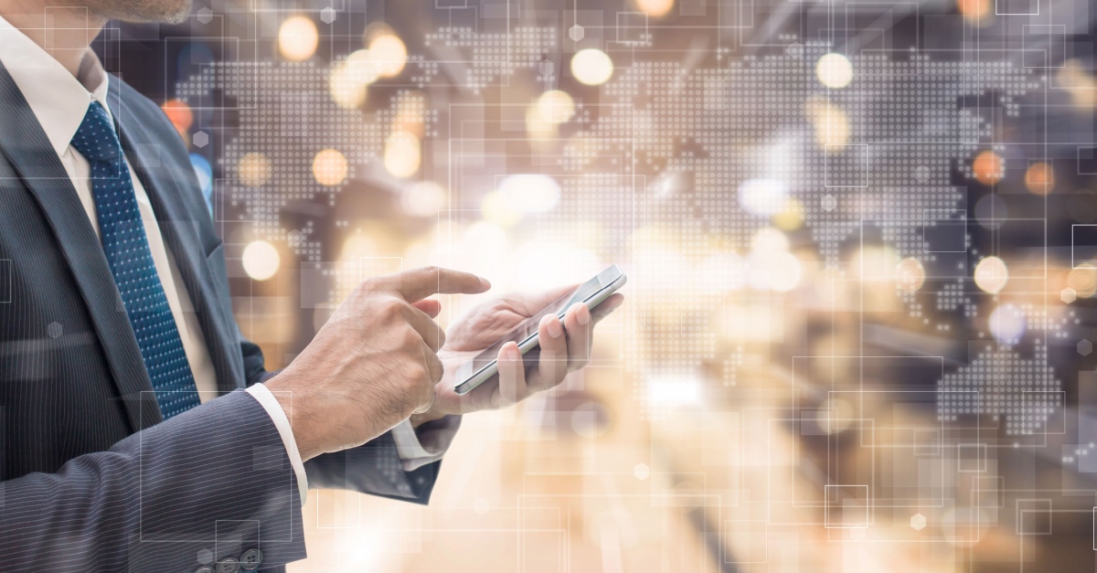Businessman in a suit using a smartphone, with blurred city lights and a digital network overlay.