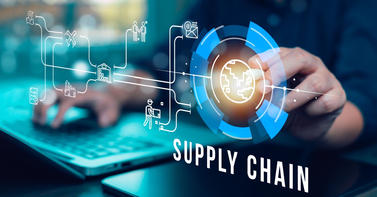 Hand touching a digital supply chain diagram above a laptop keyboard, with the words Supply Chain.