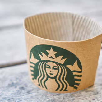 Starbucks coffee cup sleeve on a wooden surface.