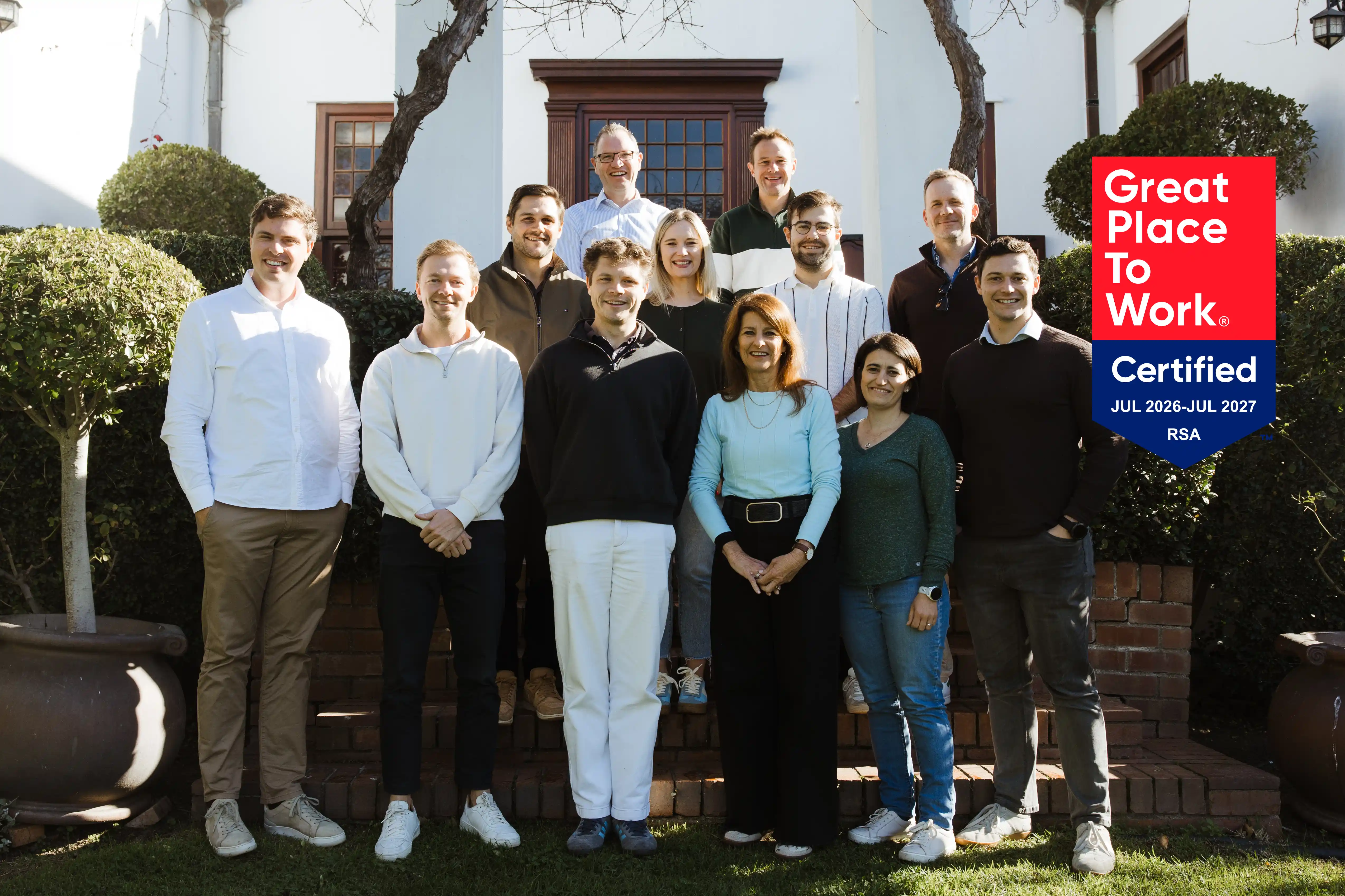 Lancia Consult South Africa team outside the Cape Town office with the Great Place To Work certification banner