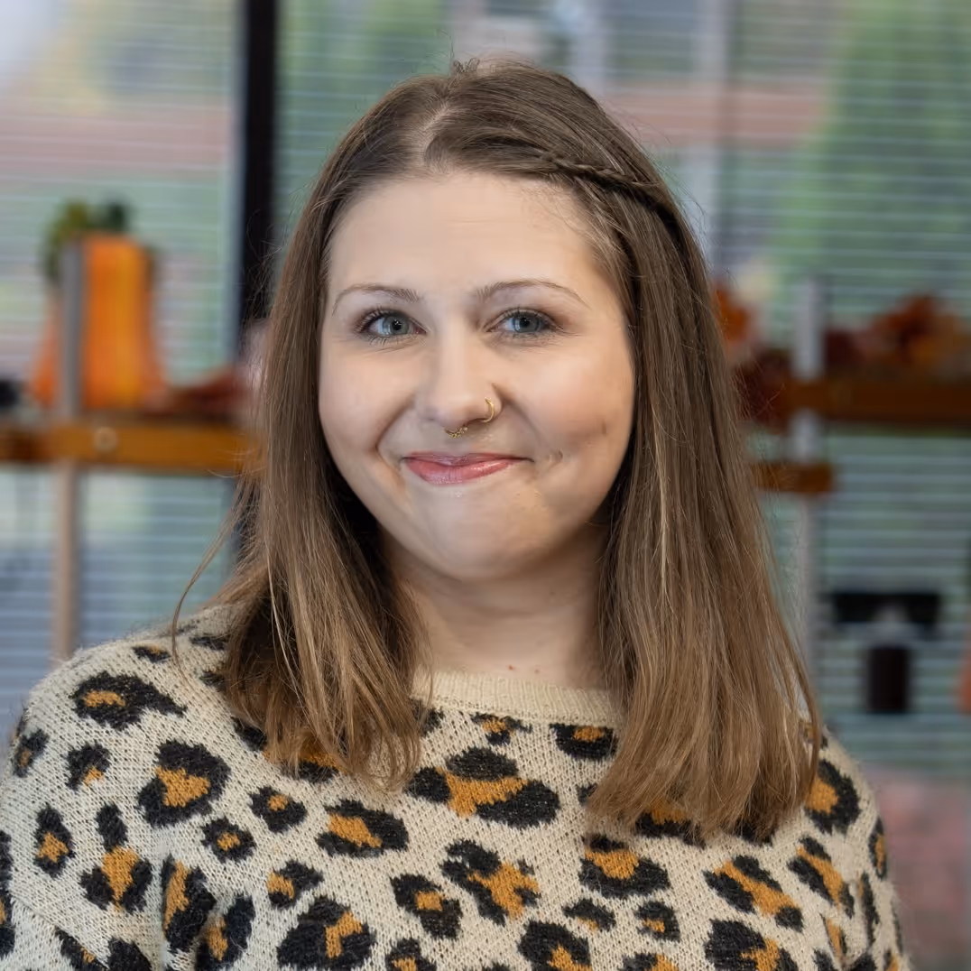 Portrait of Erica, a Vision Care Center optician, standing in a well-lit office.