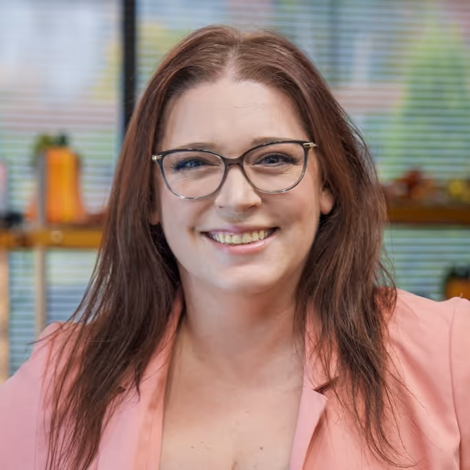Portrait of Jackie, a Vision Care Center clinic assistant, standing in a well-lit office.